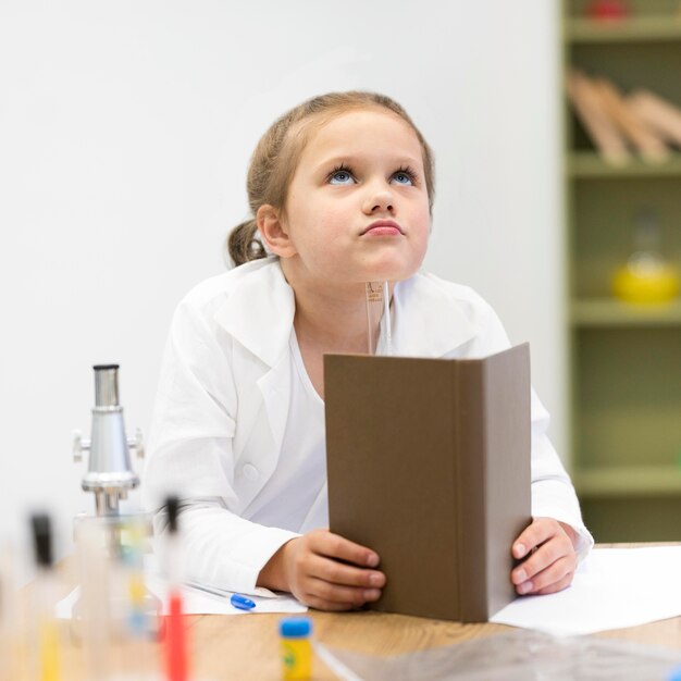 Chica en clase de ciencias con libro