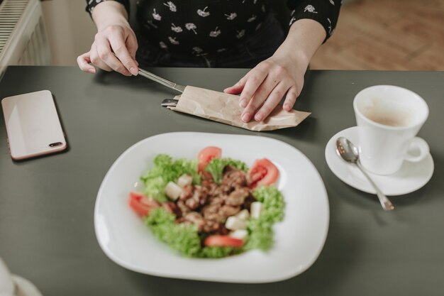 Chica comiendo una ensalada en un restaurante