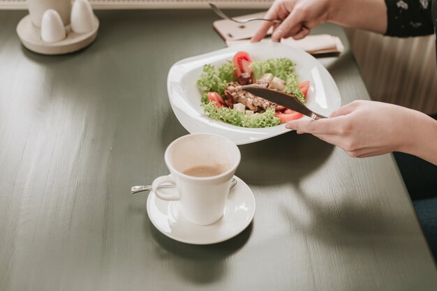 Chica comiendo una ensalada en un restaurante