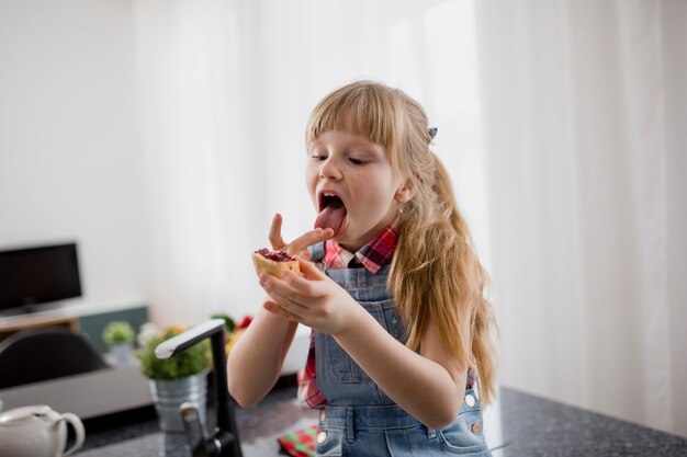 Chica comiendo sándwich abierto