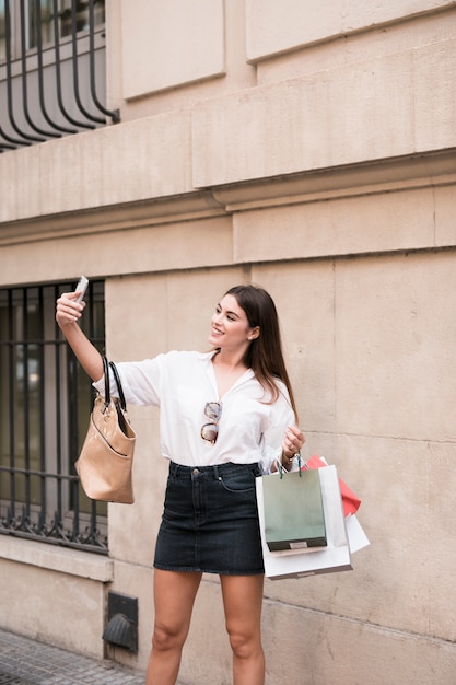 Chica de compras haciéndose un selfie