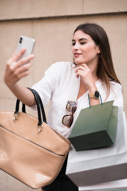 Foto gratuita chica de compras haciéndose un selfie