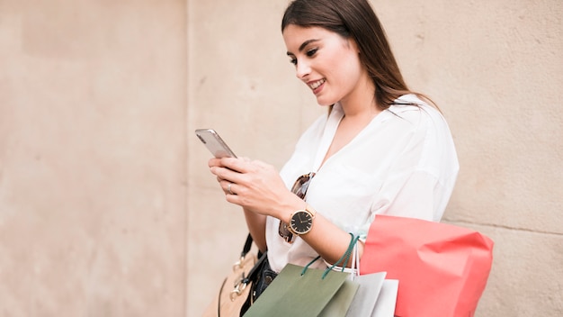 Foto gratuita chica de compras usando su móvil