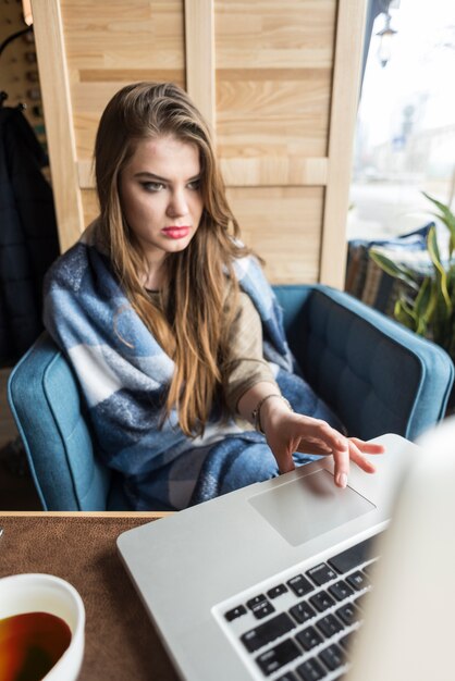 Chica concentrada mirando la pantalla de su portátil