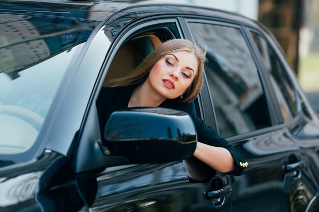 Chica conduce un coche y mira desde la ventana en el atasco de tráfico