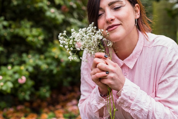 Chica contenta con flores blancas en el parque