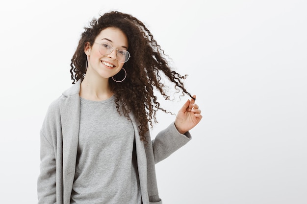 Foto gratuita chica coqueta segura pidiendo salir al chico. retrato de mujer guapa sin preocupaciones en elegante abrigo gris y gafas