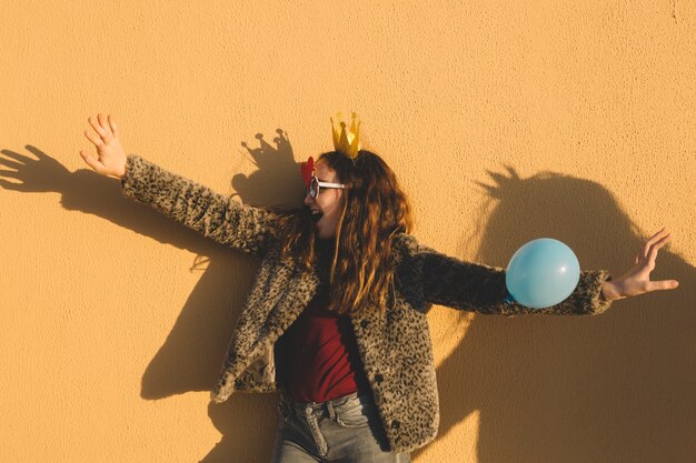 Chica en corona de papel divirtiéndose