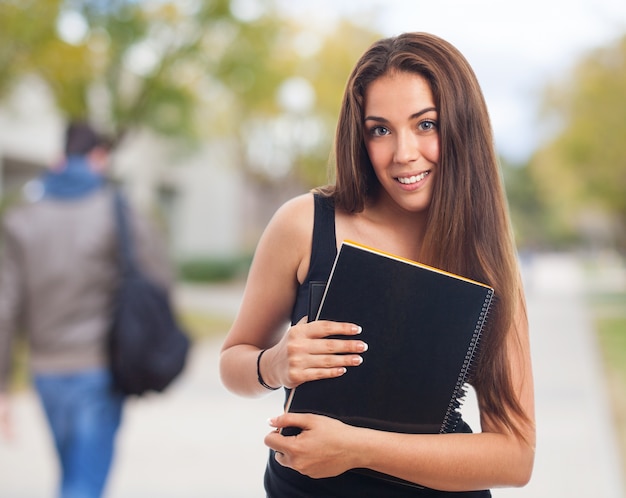 Chica con un cuaderno en la calle