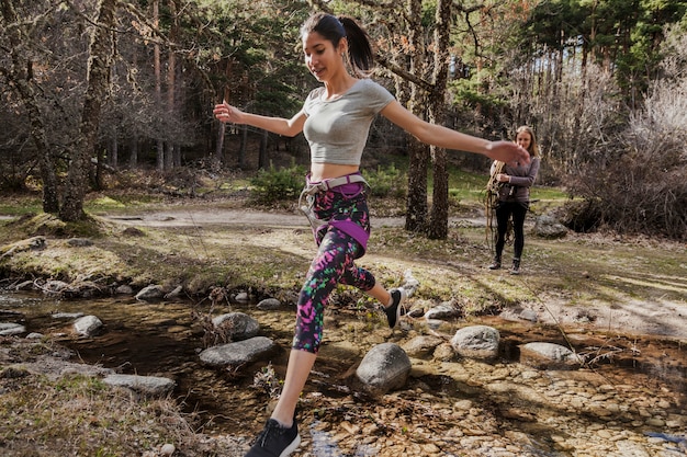 Chica con cuerdas en su cintura cruzando un río