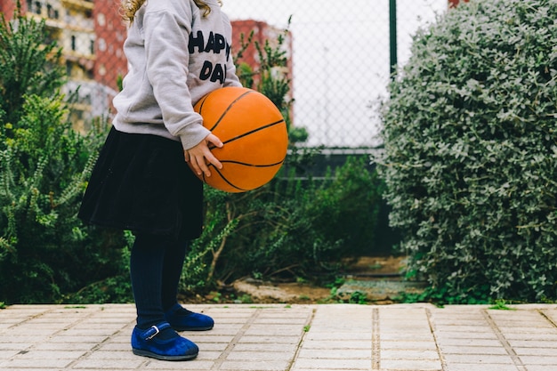 Chica de cultivo con pelota de baloncesto