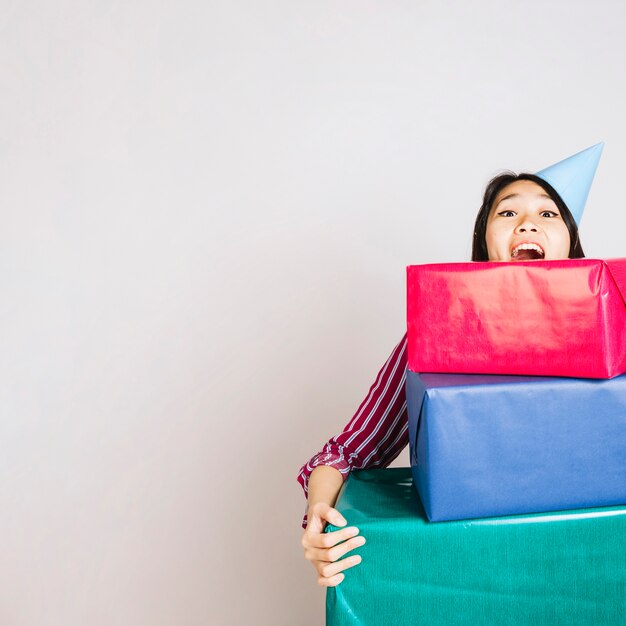 Chica de cumpleaños alegre con cajas de regalos