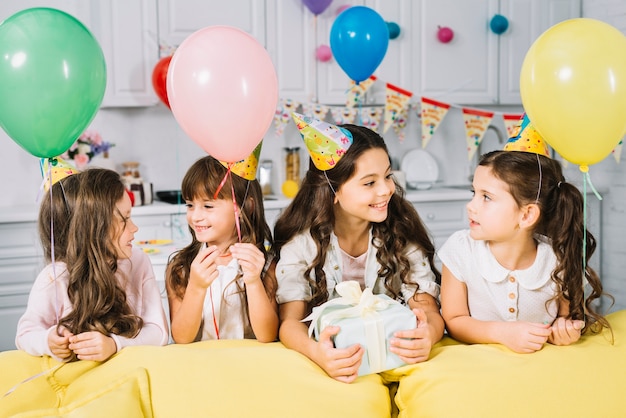 Chica de cumpleaños disfrutando de la fiesta con sus amigas en casa.