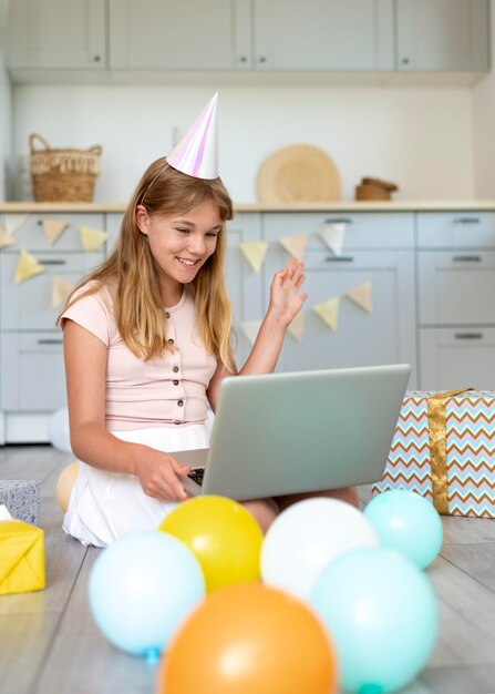 Chica de cumpleaños de tiro completo con laptop