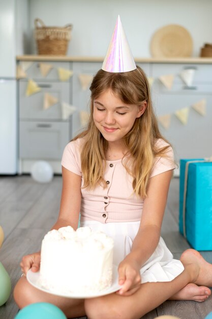 Chica de cumpleaños de tiro completo con pastel