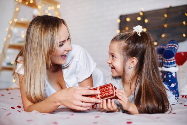 Chica dando regalo de Navidad a su mamá