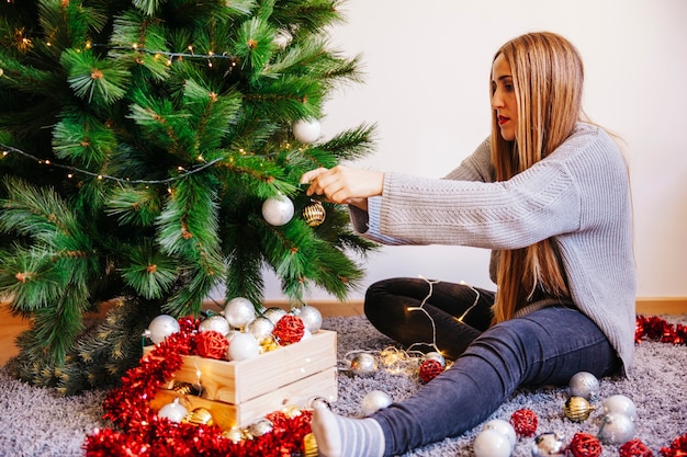 Chica decorando árbol de navidad