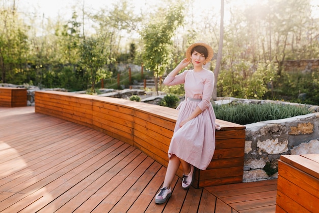 Chica delgada elegante con traje antiguo descansando en el parque en la naturaleza increíble