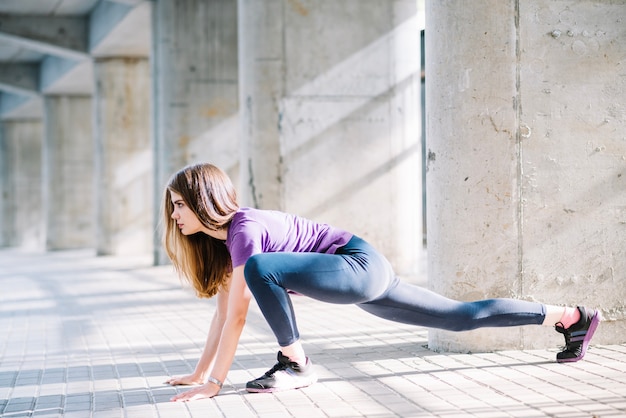 Chica deportista haciendo estiramientos en el suelo