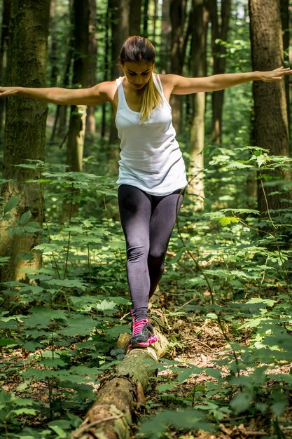 Foto gratuita chica deportiva en el bosque en el camino, calentando antes de correr, deporte