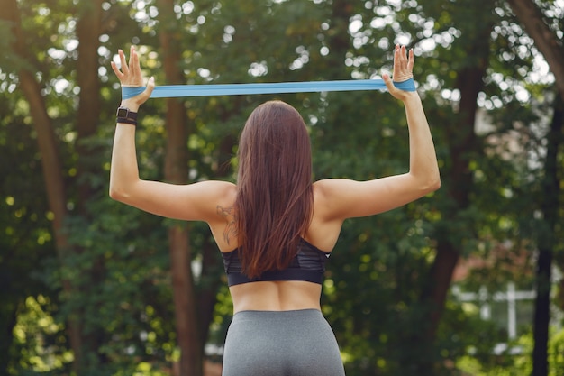 Chica deportiva entrenando con bandas elásticas deportivas