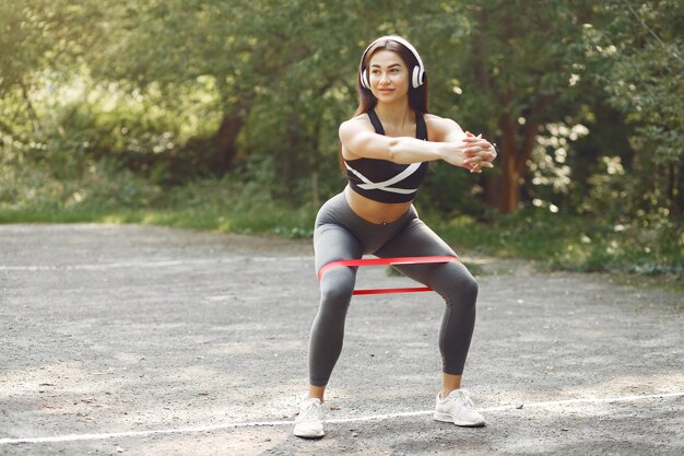 Chica deportiva entrenando con bandas elásticas deportivas