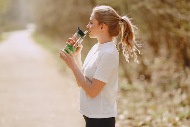 Chica deportiva entrenando en un bosque de verano