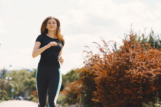 Chica deportiva entrenando en un bosque de verano