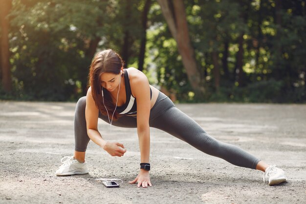 Chica deportiva entrenando con teléfono y auriculares