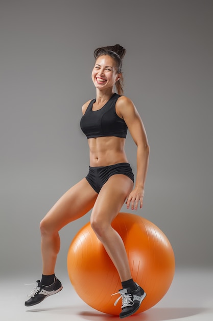 chica deportiva haciendo ejercicios en un fitball