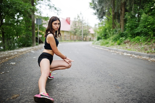 Chica deportiva en ropa deportiva haciendo ejercicio en un parque verde y entrenando en la naturaleza Un estilo de vida saludable