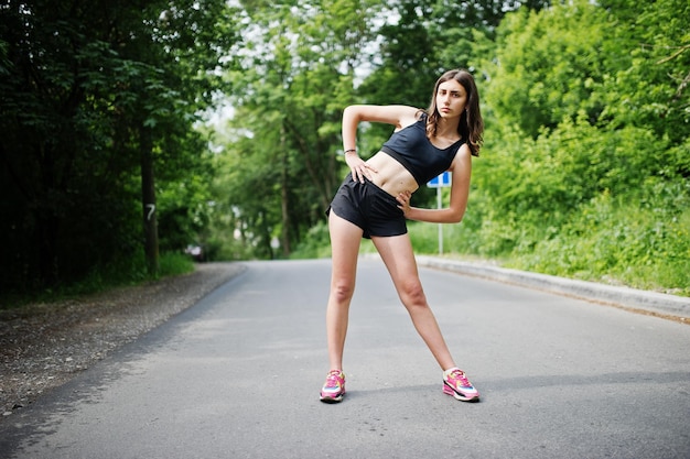 Chica deportiva en ropa deportiva haciendo ejercicio en un parque verde y entrenando en la naturaleza Un estilo de vida saludable