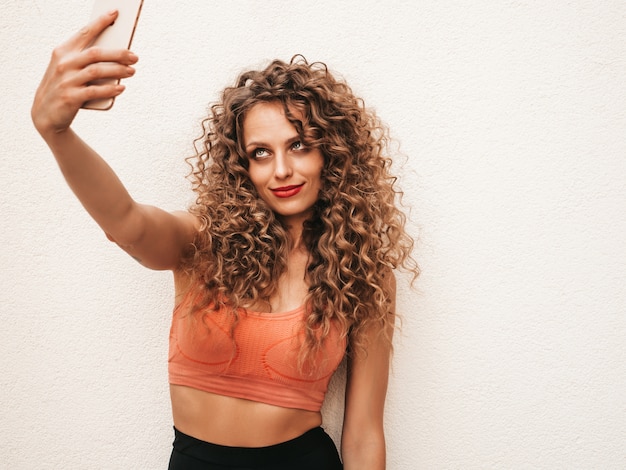 Chica despreocupada posando en la calle tomando una selfie