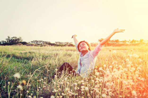 Chica disfrutando de un campo con flores