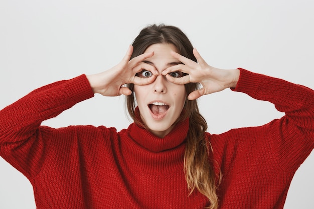 Chica divertida hacer gafas de mano