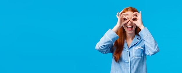 Chica divertida viendo promoción maravillosa quiere probar mujer pelirroja atractiva en pijama encantador hacer vidrio