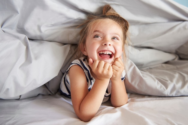 Chica divirtiéndose en su cama