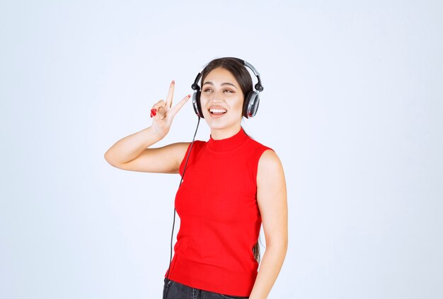 Chica Dj con auriculares enviando mensaje de paz y amistad.