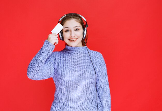 Chica Dj con auriculares presentando su tarjeta de visita.