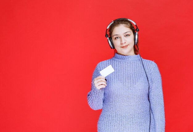 Chica Dj con auriculares presentando su tarjeta de visita.