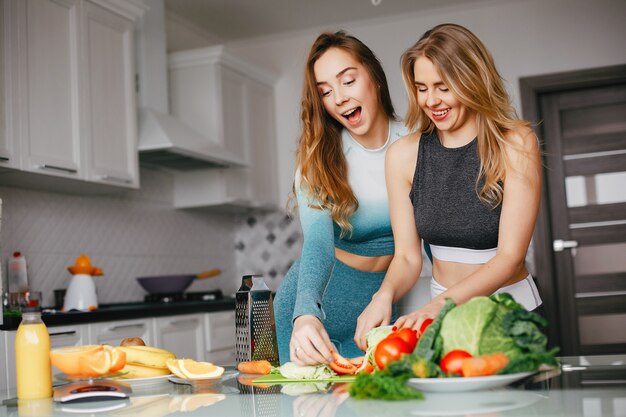 Chica de dos deportes en una cocina con verduras