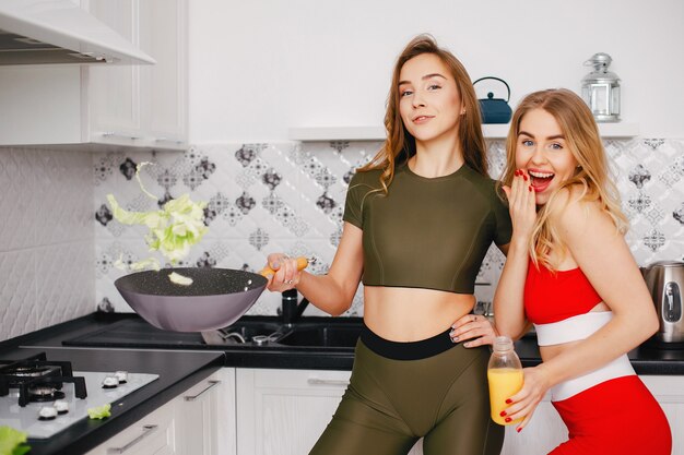 Chica de dos deportes en una cocina con verduras