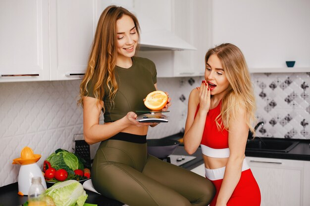 Chica de dos deportes en una cocina con verduras