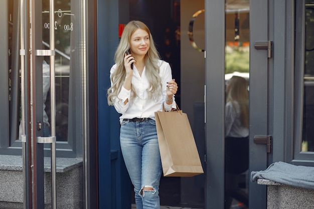 Chica elegante con bolsa de compras en una ciudad