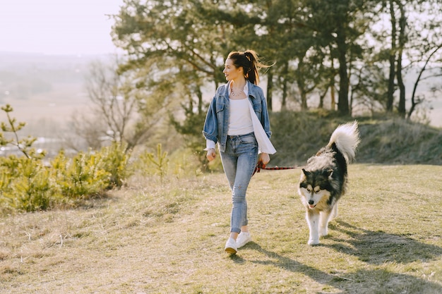 Chica elegante en un campo soleado con un perro