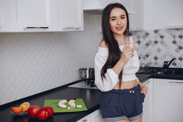Chica elegante en una cocina con frutas.