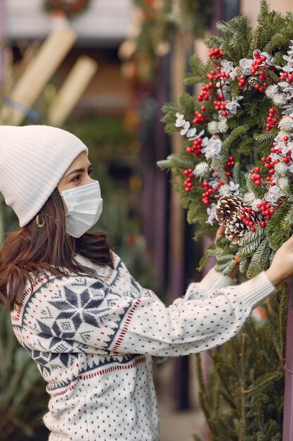 Chica elegante compra un árbol de Navidad.