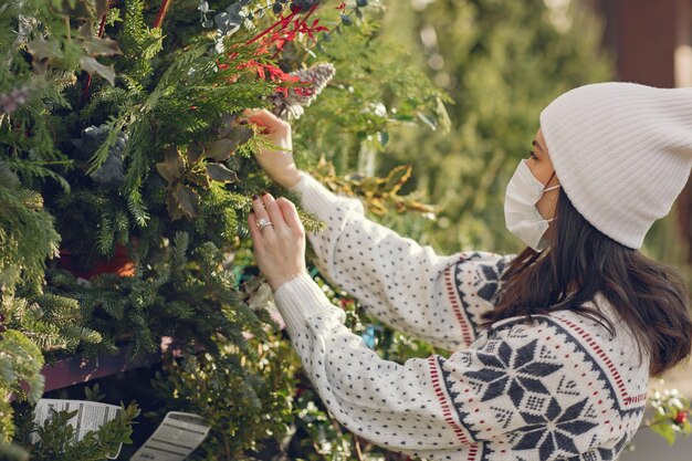 Chica elegante compra un árbol de Navidad.