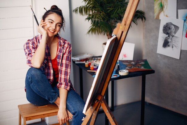 Chica elegante dibuja en un estudio de arte.