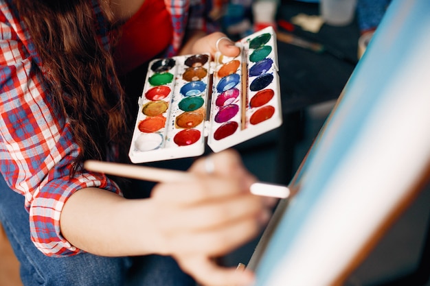 Chica elegante dibuja en un estudio de arte.